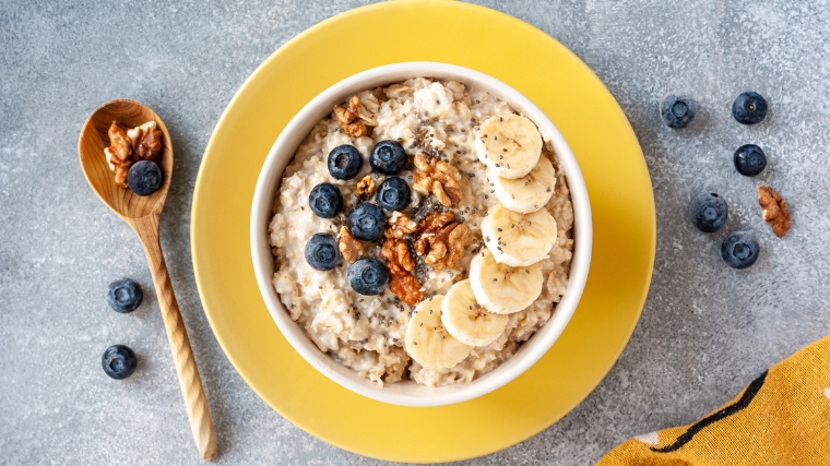 A bowl of oatmeal with fruits.